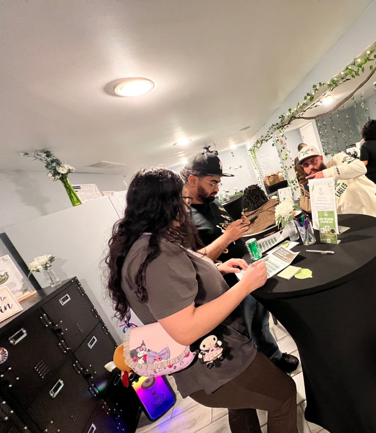 Community members signing in at The Canopy Collective welcome table during a gathering.